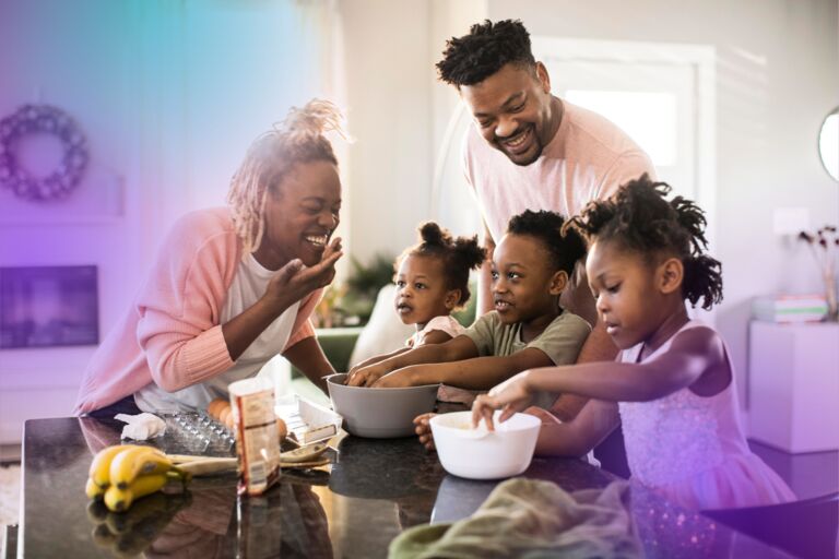 Happy smiling and laughing black couple with their 3 children in their kitchen