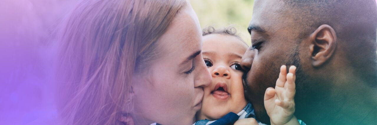 Couple holding their baby and kissing baby's cheeks