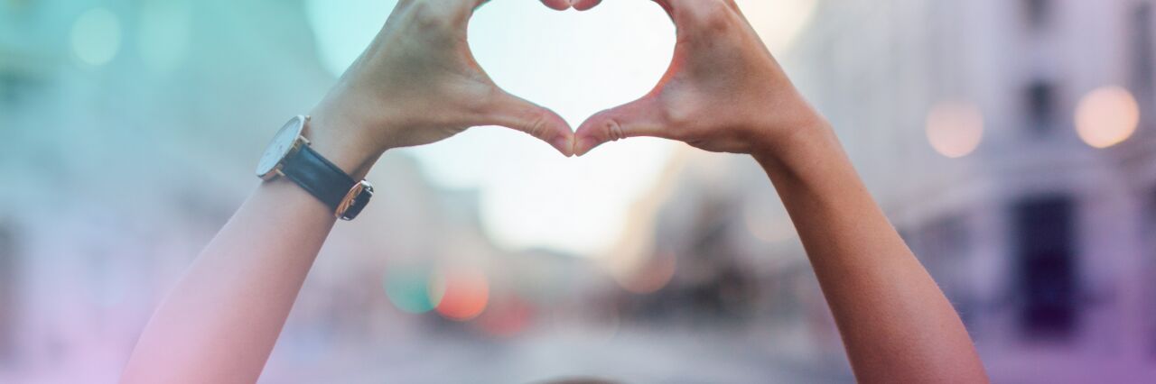 person making a heart shape with hands