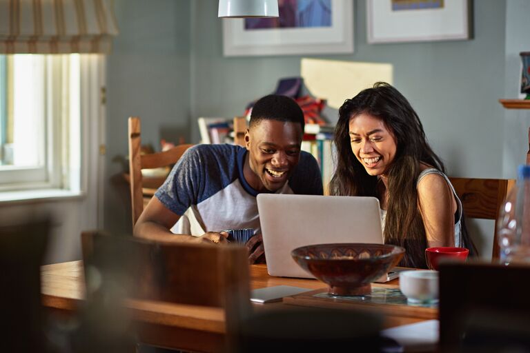 Smiling couple using laptop