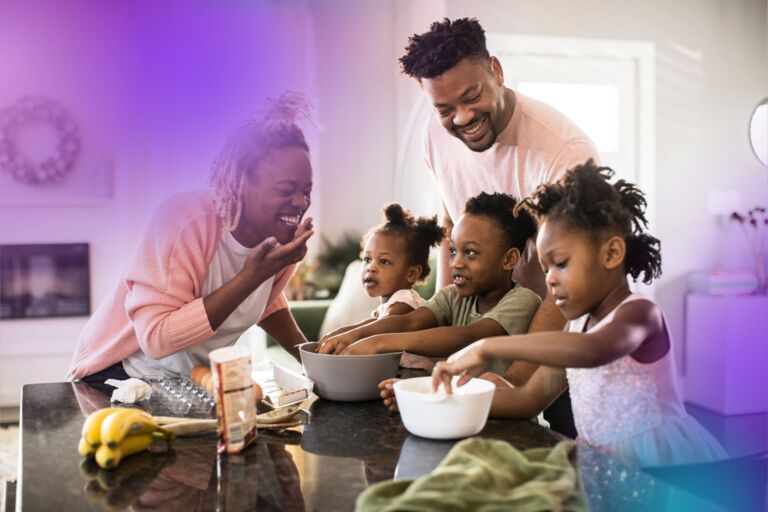Happy smiling and laughing black couple with their 3 children in their kitchen