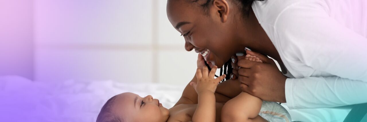 Black, single, female smiling and laughing with baby 