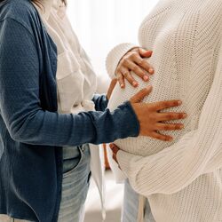 LGBTQ+ females holding a pregnancy bump