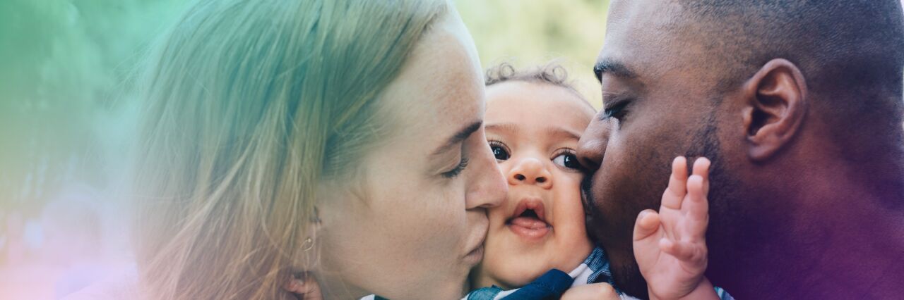 Couple holding their baby and kissing baby's cheeks